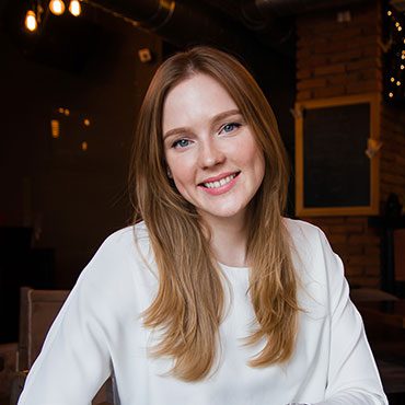 Here's an alt tag for the image: Smiling woman with long light brown hair.